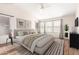 Staged bedroom with wood floors, a large bed, and bright natural light from several windows at 1470 S Villas Ct, Chandler, AZ 85286