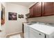 Modern laundry room with front-loading washer and dryer, and dark wood cabinetry at 16341 E Links Dr, Fountain Hills, AZ 85268