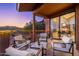Covered patio boasting comfortable seating, desert views, outdoor lighting, and sliding glass door into living area at 16341 E Links Dr, Fountain Hills, AZ 85268