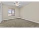 Bright bedroom featuring neutral carpet, a ceiling fan, and a window at 1656 E Halifax St, Mesa, AZ 85203