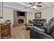 Cozy living room featuring a brick fireplace, ceiling fan, and comfortable leather furniture at 1656 E Halifax St, Mesa, AZ 85203