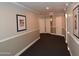 Long hallway with neutral tones, crown molding, and decorative sconce lighting at 1701 E Colter St # 191, Phoenix, AZ 85016