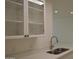 Well-lit kitchen featuring quartz countertops, stainless steel sink, and sleek glass-front cabinets at 1701 E Colter St # 191, Phoenix, AZ 85016