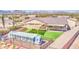 Desert residence aerial view showcases backyard artificial grass, sunshade, and charming chicken coop at 1727 E Hidalgo St, Apache Junction, AZ 85119