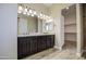 Bathroom with double vanity, granite countertops, dark cabinets and entry to large closet at 1727 E Hidalgo St, Apache Junction, AZ 85119