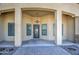 Covered front porch with detailed iron door, sconces and brick-paved walkway at 1727 E Hidalgo St, Apache Junction, AZ 85119