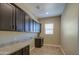 Laundry room with plenty of cabinet space, tile flooring and sink at 1727 E Hidalgo St, Apache Junction, AZ 85119