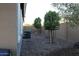 Low-maintenance backyard with gravel landscaping and mature trees, offering privacy at 18006 W Hess St, Goodyear, AZ 85338