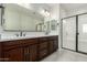 Bathroom with a double sink vanity, a large mirror, and glass enclosed shower at 18006 W Hess St, Goodyear, AZ 85338
