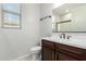 Bathroom featuring a dark vanity, dual sinks, and a large framed mirror at 18006 W Hess St, Goodyear, AZ 85338