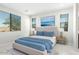 Airy bedroom with large windows, ocean-themed art, and plush rug creates a serene atmosphere at 18006 W Hess St, Goodyear, AZ 85338