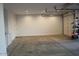 Clean garage with concrete floor, white walls, and storage shelves off to one side at 18006 W Hess St, Goodyear, AZ 85338