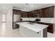 Modern kitchen with stainless steel appliances, center island, and dark cabinets at 18006 W Hess St, Goodyear, AZ 85338