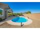 Serene backyard featuring a sparkling pool, desert landscaping, and an outdoor lounge area at 18006 W Hess St, Goodyear, AZ 85338