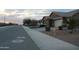 A serene street view shows well-maintained homes and landscaping at dusk at 18006 W Hess St, Goodyear, AZ 85338