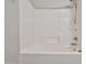 Clean, white tiled shower-tub combination features a shower head and convenient shelving space at 1930 E Hayden Ln # 118, Tempe, AZ 85281