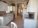 Spacious kitchen with white cabinetry, tiled countertops, and a view into the dining room at 19420 N Westbrook Pkwy # 510, Peoria, AZ 85382