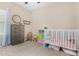 Charming Bedroom features a crib, dresser, and playful decor at 2225 E Andalusian Loop, San Tan Valley, AZ 85140