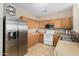 Bright kitchen with stainless steel refrigerator, white range, and plenty of cabinet space at 2225 E Andalusian Loop, San Tan Valley, AZ 85140