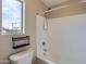 This bathroom has a shower and tub combination, with a toilet near a window at 23619 W Harrison Dr, Buckeye, AZ 85326