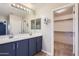 Bathroom featuring a double sink vanity and mirror, alongside a walk-in closet at 23619 W Harrison Dr, Buckeye, AZ 85326