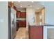 Open kitchen with stainless steel refrigerator, wooden cabinets and tiled floor at 23619 W Harrison Dr, Buckeye, AZ 85326