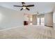 Spacious living room features a ceiling fan, carpet floors, and sliding glass doors at 23619 W Harrison Dr, Buckeye, AZ 85326