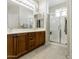 Bright bathroom with dual sinks, wood cabinets, and a glass-enclosed shower at 24822 S Sedona Dr, Sun Lakes, AZ 85248