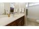 Well-lit bathroom with white countertop, wood cabinets, and combination shower and tub at 24822 S Sedona Dr, Sun Lakes, AZ 85248