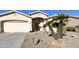 Inviting home featuring a two-car garage, desert landscaping, and a welcoming entrance with potted plants at 24822 S Sedona Dr, Sun Lakes, AZ 85248