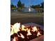 Relaxing outdoor space featuring a cozy fire pit, with a lake and fountain in the background at 24822 S Sedona Dr, Sun Lakes, AZ 85248