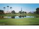 Beautiful community golf course view featuring a calm lake and well-maintained green with residential homes in background at 24822 S Sedona Dr, Sun Lakes, AZ 85248