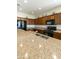 Large kitchen island with sink, granite countertops, black appliances, and wood cabinetry at 24822 S Sedona Dr, Sun Lakes, AZ 85248