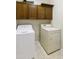 Functional laundry room with washer, dryer, and cabinets for storage at 24822 S Sedona Dr, Sun Lakes, AZ 85248