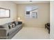 Cozy living room featuring neutral walls, plush carpeting, a comfortable sofa, and ample natural light at 24822 S Sedona Dr, Sun Lakes, AZ 85248