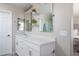 Bright bathroom vanity with double mirrors, shelving, white cabinets, and a solid surface countertop at 25930 N Thornhill Dr, Peoria, AZ 85383