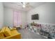 Spacious playroom with cozy yellow couch and colorful floral decorated accent wall at 25930 N Thornhill Dr, Peoria, AZ 85383