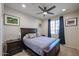 Cozy bedroom with carpet flooring, a ceiling fan, and a beautiful framed bed at 26955 W Adam Ave, Buckeye, AZ 85396