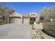 Charming single-story home featuring desert landscaping, a three-car garage, and a welcoming front entrance at 28604 N 92Nd Pl, Scottsdale, AZ 85262