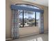 Living room featuring a large window with decorative curtains and scenic outdoor views at 28604 N 92Nd Pl, Scottsdale, AZ 85262