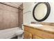 Bathroom with a tile surround shower/tub, a light wood vanity and a round framed mirror at 4003 S Mill Ave, Tempe, AZ 85282