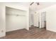 A bedroom with light colored walls, wood-look floors, and an open closet with a hanging rod and shelves at 4003 S Mill Ave, Tempe, AZ 85282