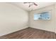 Bright room showcasing light walls, wood-look floors, a window and a ceiling fan with a light fixture at 4003 S Mill Ave, Tempe, AZ 85282
