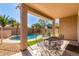 Covered patio with outdoor seating area overlooking a fenced pool and green turf at 4245 E Maya Way, Cave Creek, AZ 85331