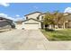 Charming two-story home with a well-manicured front yard, mature tree, and a spacious three-car garage at 4304 E Whitehall Dr, San Tan Valley, AZ 85140