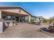 Expansive backyard featuring a covered patio, outdoor seating, built-in grill, and meticulously landscaped desert scenery at 4876 N 206Th Ln, Buckeye, AZ 85396