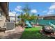 Turfed backyard featuring a cozy seating area, mature trees, and a decorative trellis, ideal for outdoor enjoyment at 5141 E Elena Ave, Mesa, AZ 85206