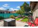 A well-maintained backyard with artificial turf, brick accents, mature tree, and an outdoor seating area at 5141 E Elena Ave, Mesa, AZ 85206