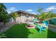 Turfed backyard showcases outdoor seating with a fire pit and vibrant landscaping, perfect for relaxation at 5141 E Elena Ave, Mesa, AZ 85206
