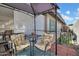 Relax on this charming patio with floral seating, a bistro table, and adjacent artificial turf with white decorative fence at 5141 E Elena Ave, Mesa, AZ 85206